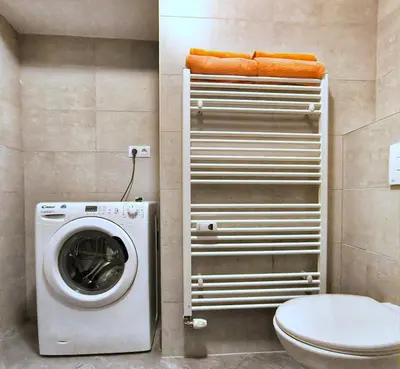 a bathroom with a washing machine and a toilet at Isabel's Suites in Prague