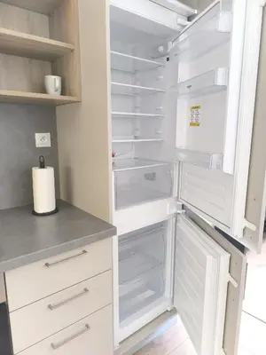 a kitchen with white cabinets and an empty refrigerator at Isabel's Suites in Prague