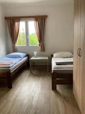 a bedroom with two beds and a window at Penzion Cholín in Nový Knín