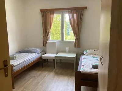 a small room with a bed and a window at Penzion Cholín in Nový Knín