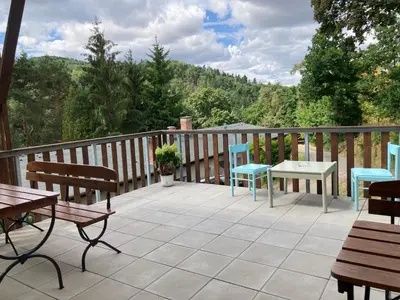 a deck with benches and tables and a view at Penzion Cholín in Nový Knín