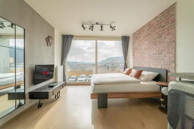 a bedroom with a bed and a brick wall at IndustriaLux Suite by Rentez in Prague