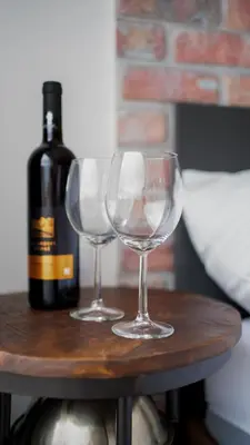 two wine glasses on a table with a bottle of wine at IndustriaLux Suite by Rentez in Prague