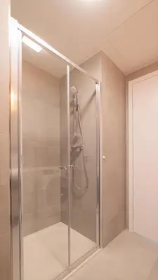 a shower with a glass door in a bathroom at IndustriaLux Suite by Rentez in Prague