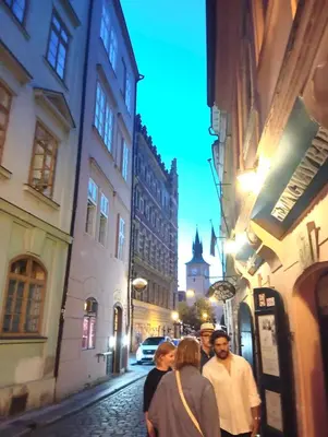 a group of people walking down a street at night at Prague centrum house in Prague