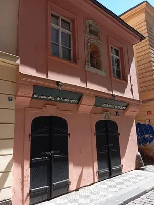 a pink building with black doors on a street at Prague centrum house in Prague