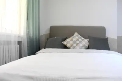 a bedroom with a white bed with pillows and a window at Prague City Centre Apartment in Prague
