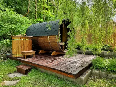 a small wooden house with a bench on a wooden deck at Chillzóna u Medojeda in Chyňava