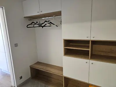 a closet with white cabinets and wooden shelves at Prague Centre Luxury Apartment & Parking in Prague