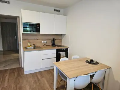 a kitchen with white cabinets and a wooden table at Prague Centre Luxury Apartment & Parking in Prague