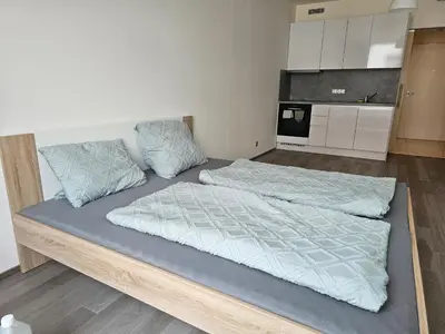 a large bed in a room with a kitchen at Prague Centre Luxury Apartment & Parking in Prague