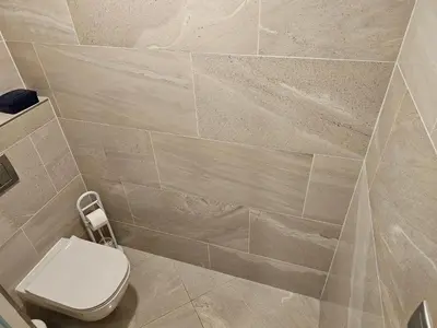 a bathroom with a toilet and a tiled wall at Prague Centre Luxury Apartment & Parking in Prague
