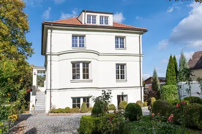 a white house with a red roof at Romantický apartmán se starožitným interiérem in Mořina