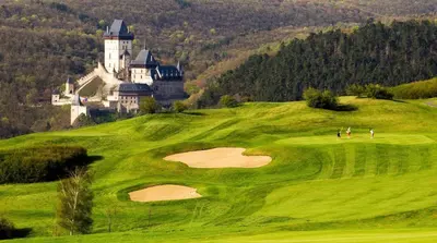 a golf course with a castle in the background at Romantický apartmán se starožitným interiérem in Mořina