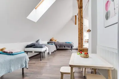 a living room with several beds and a table at Ultimate Prague 1 experience - Duplex, Roof Top Terrace, Prague Castle View, free parking over weekends, AC! in Prague