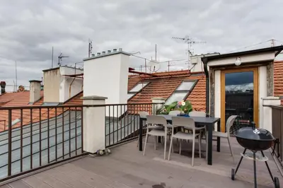 a patio with a table and chairs on a balcony at Ultimate Prague 1 experience - Duplex, Roof Top Terrace, Prague Castle View, free parking over weekends, AC! in Prague