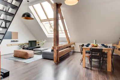 a living room with a dining table and a loft at Ultimate Prague 1 experience - Duplex, Roof Top Terrace, Prague Castle View, free parking over weekends, AC! in Prague