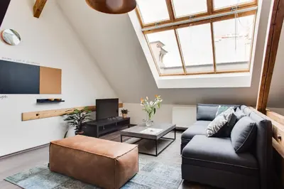 a living room with a couch and a tv at Ultimate Prague 1 experience - Duplex, Roof Top Terrace, Prague Castle View, free parking over weekends, AC! in Prague
