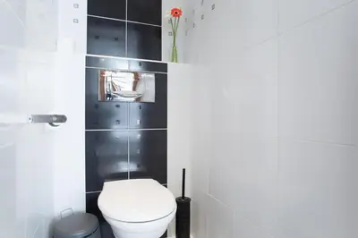 a bathroom with a white toilet and black tiles at Ultimate Prague 1 experience - Duplex, Roof Top Terrace, Prague Castle View, free parking over weekends, AC! in Prague