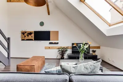 a living room with a couch and a table at Ultimate Prague 1 experience - Duplex, Roof Top Terrace, Prague Castle View, free parking over weekends, AC! in Prague