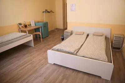 a room with two beds and a table and a desk at Koreatown in Prague