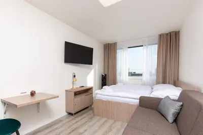 a hotel room with a bed and a couch at SKYLINE PRAGUE Apartments in Prague