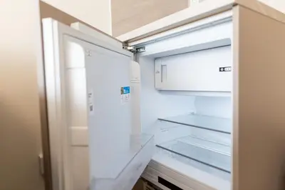 an empty refrigerator with its door open in a kitchen at SKYLINE PRAGUE Apartments in Prague