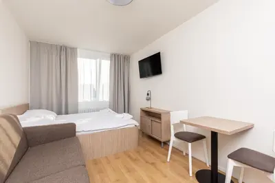 a hotel room with a bed and a desk at SKYLINE PRAGUE Apartments in Prague