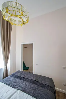 a bedroom with a bed and a chandelier at 3BDR Elegance Deco Downtown Flat in Prague