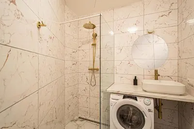 a bathroom with a washing machine and a shower at 3BDR Elegance Deco Downtown Flat in Prague