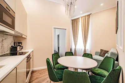 a living room with a table and green chairs at 3BDR Elegance Deco Downtown Flat in Prague