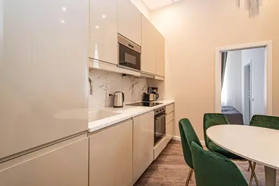 a kitchen with a table and green chairs at 3BDR Elegance Deco Downtown Flat in Prague