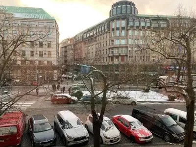 a group of cars parked in a parking lot with buildings at T1-Wenceslas square in Prague