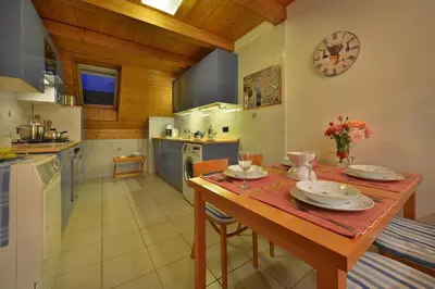 a kitchen with a wooden table and a clock on the wall at Old Town Apartments Tyn in Prague