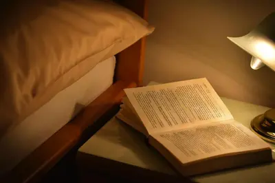 an open book on a table next to a bed at Old Town Apartments Tyn in Prague