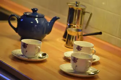 two cups and saucers on a table with a tea pot at Old Town Apartments Tyn in Prague