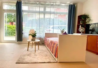 a bedroom with a bed and a table and a window at Green Studio Praha 2 l Ground floor Free PARKING in Prague