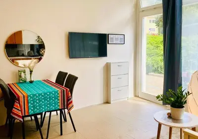 a dining room with a table and a tv on the wall at Green Studio Praha 2 l Ground floor Free PARKING in Prague