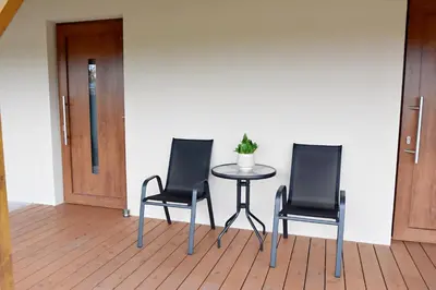 three chairs and a table with a potted plant on it at PENZION u Restaurace Na Koreji in Štětí