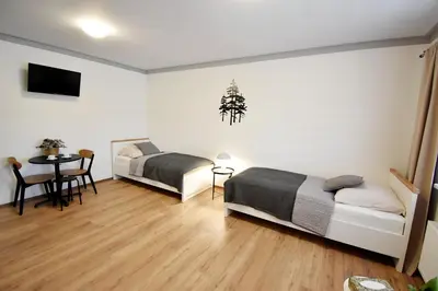a bedroom with two beds and a table with a tableablish at PENZION u Restaurace Na Koreji in Štětí