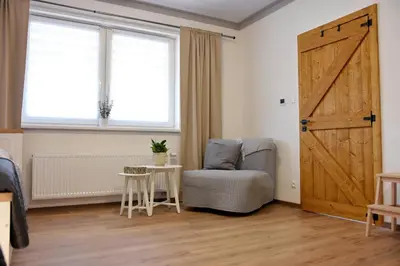 a room with a door and a chair and a table at PENZION u Restaurace Na Koreji in Štětí
