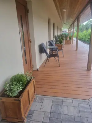 a wooden deck with chairs and a table on it at PENZION u Restaurace Na Koreji in Štětí