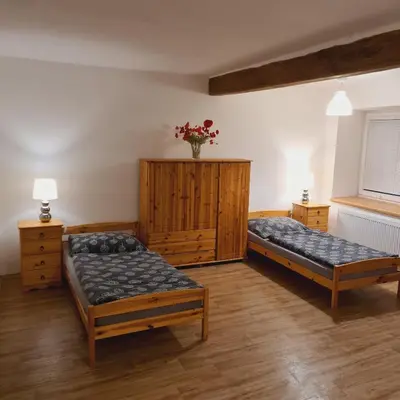 a bedroom with two beds and a wooden cabinet at Votice Luční in Wotitz
