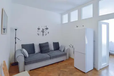 a living room with a couch in a white room at Modern Apartment Navrátilova II in Prague