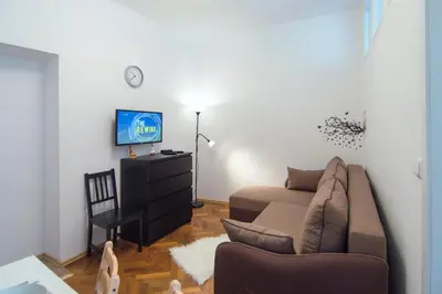 a living room with a couch and a tv at Modern Apartment Navrátilova II in Prague