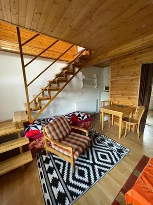 a living room with a staircase and a couch and a table at Hostinec- Pension U Havlů in Třebenice