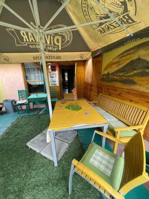 a table and chairs sitting under a large umbrella at Hostinec- Pension U Havlů in Třebenice