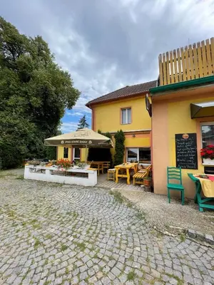 a building with a restaurant with a table and chairs at Hostinec- Pension U Havlů in Třebenice
