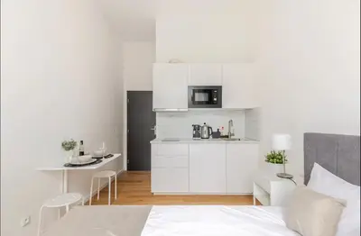 a bedroom with a bed and a small kitchen at Apartman Namesti Miru in Prague