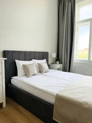 a bed with white sheets and pillows in a bedroom at Apartman Namesti Miru in Prague